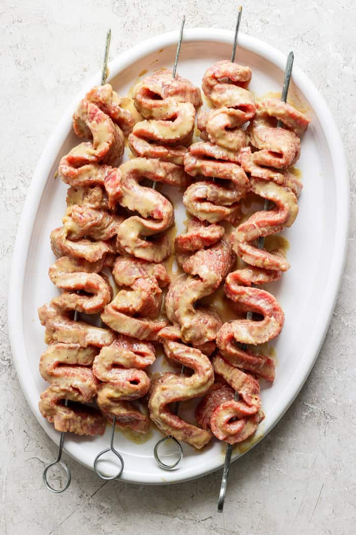 Overhead view of coconut marinated beef threaded onto skewers for satay