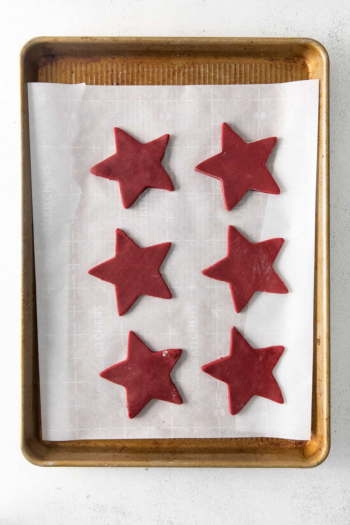 Red velvet shortbread star cookies on a baking sheet