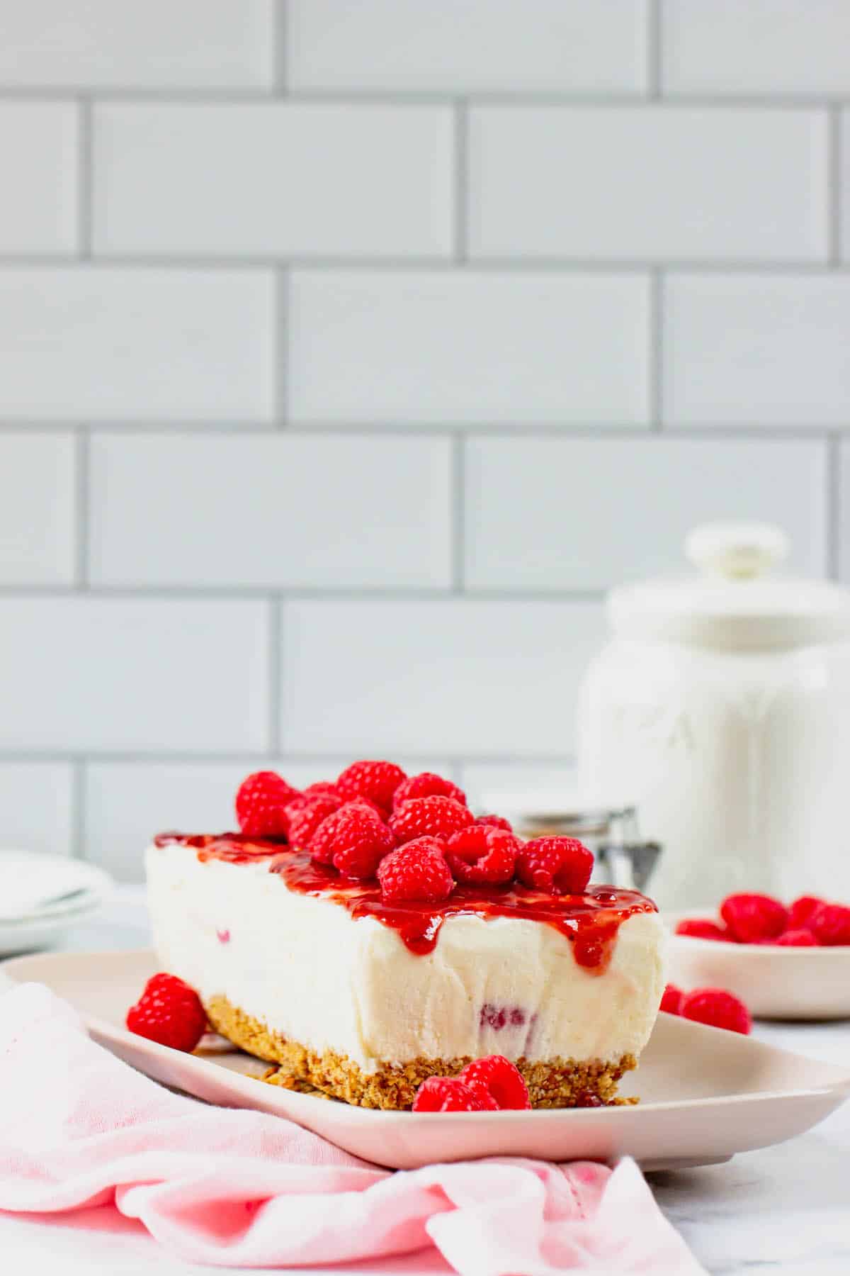 Frozen white chocolate raspberry dessert topped with fresh raspberries