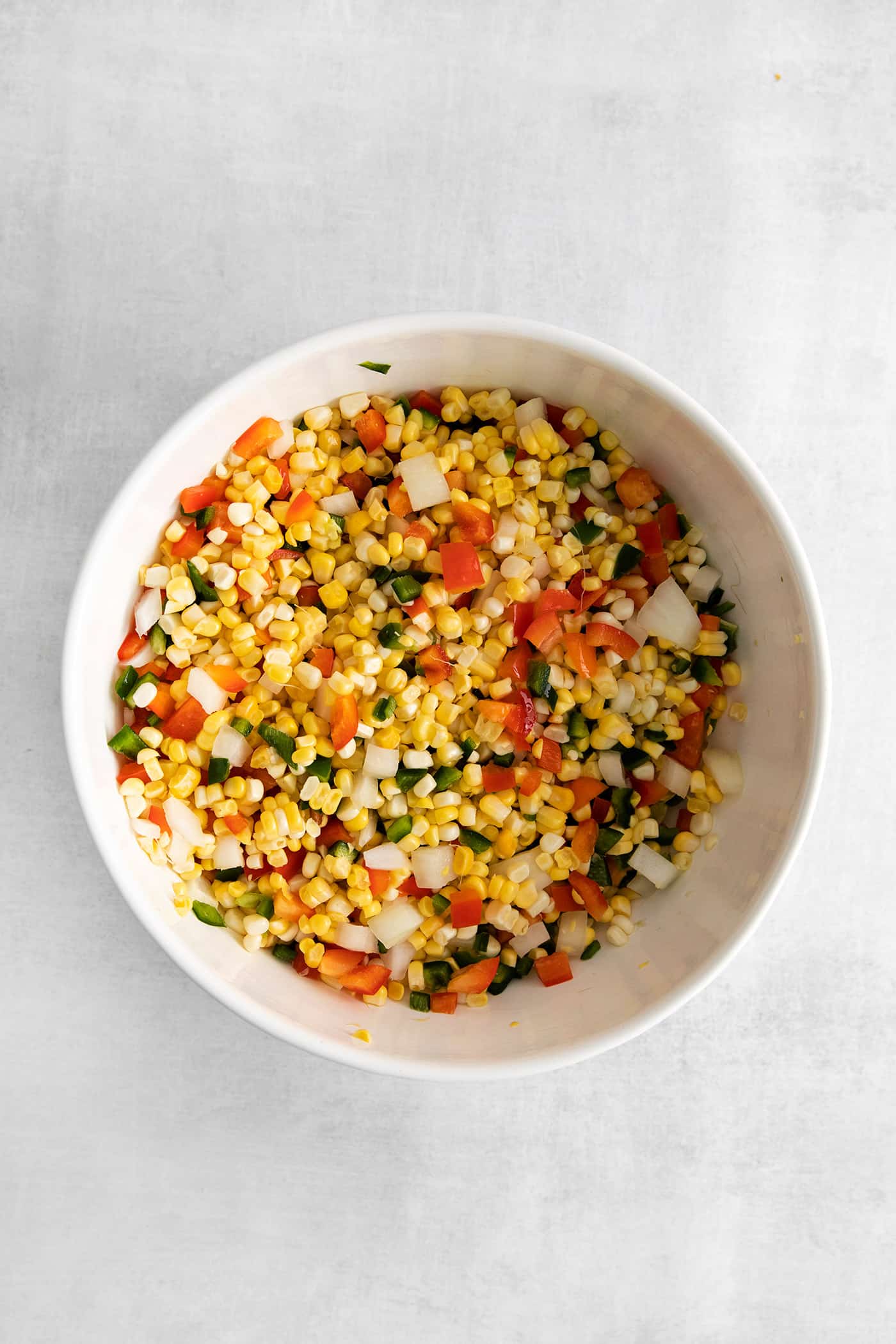 Corn, peppers, and onions mixed in a bowl