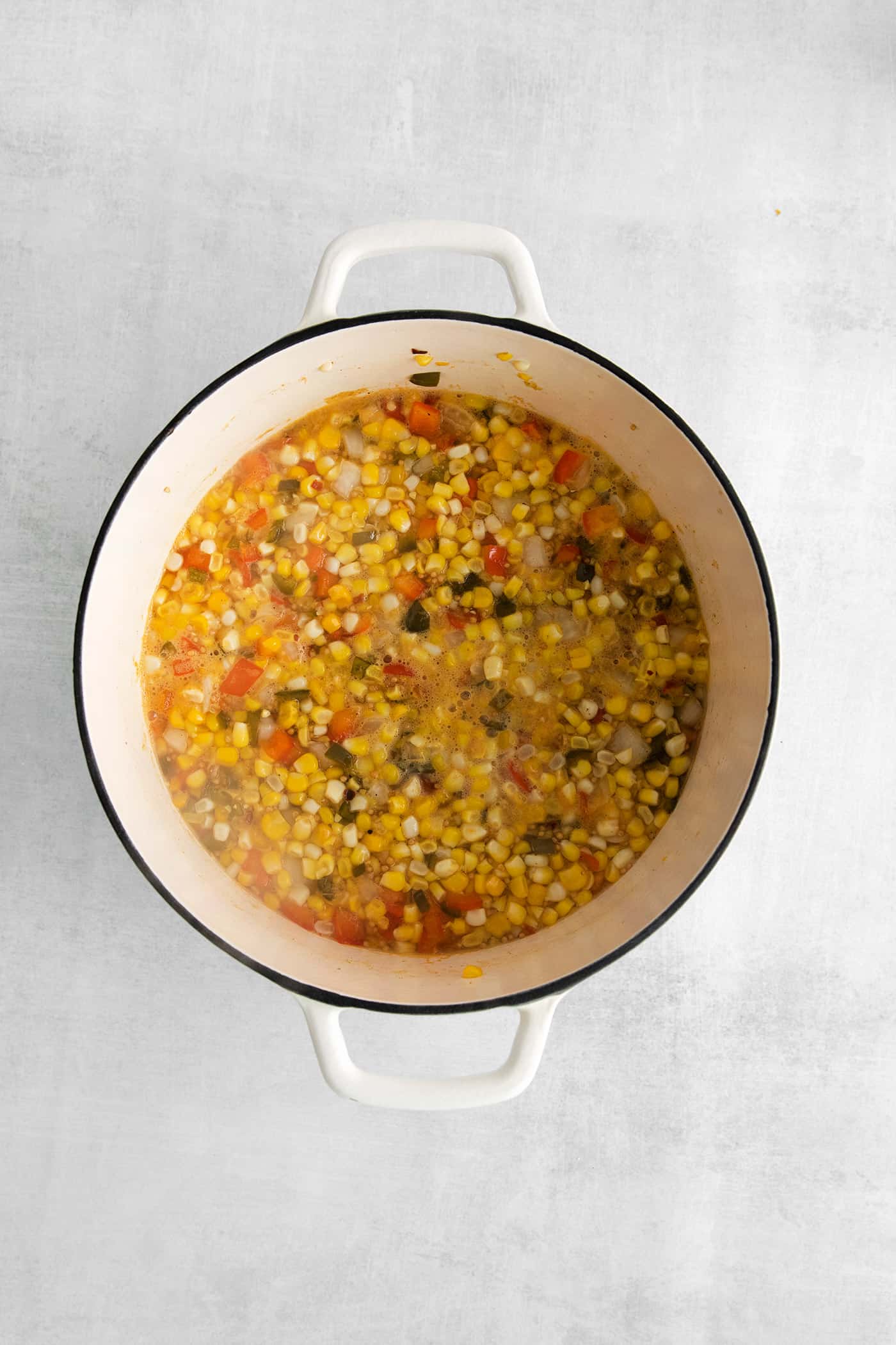 Corn, peppers, and onions in a vinegar mixture in a bowl