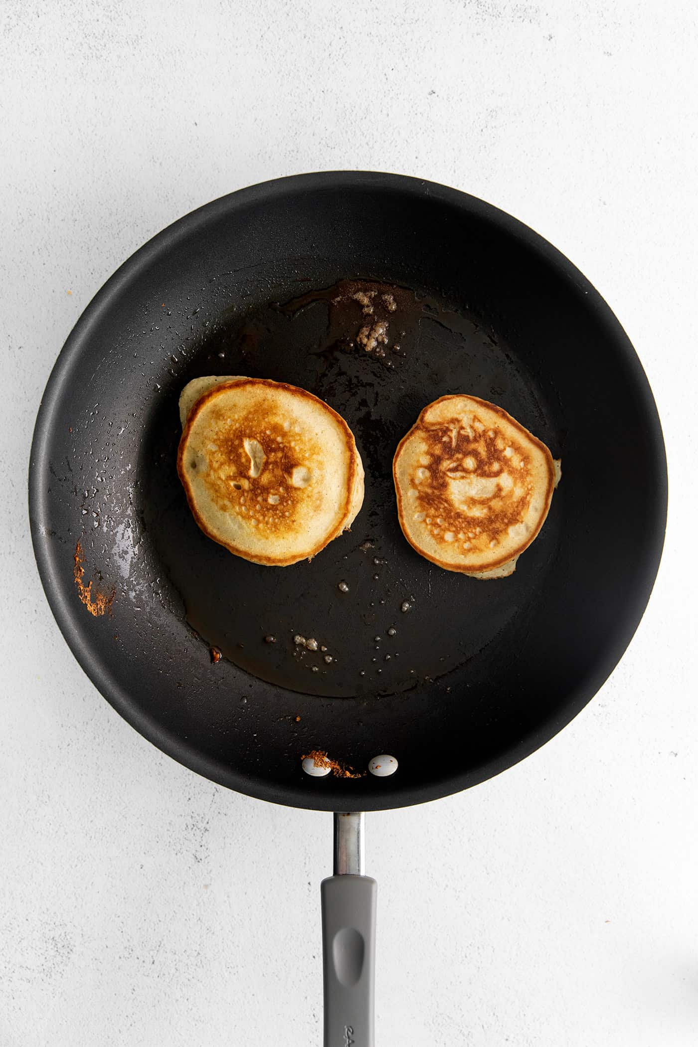 Overhead view of two pancakes in a cast iron skillet