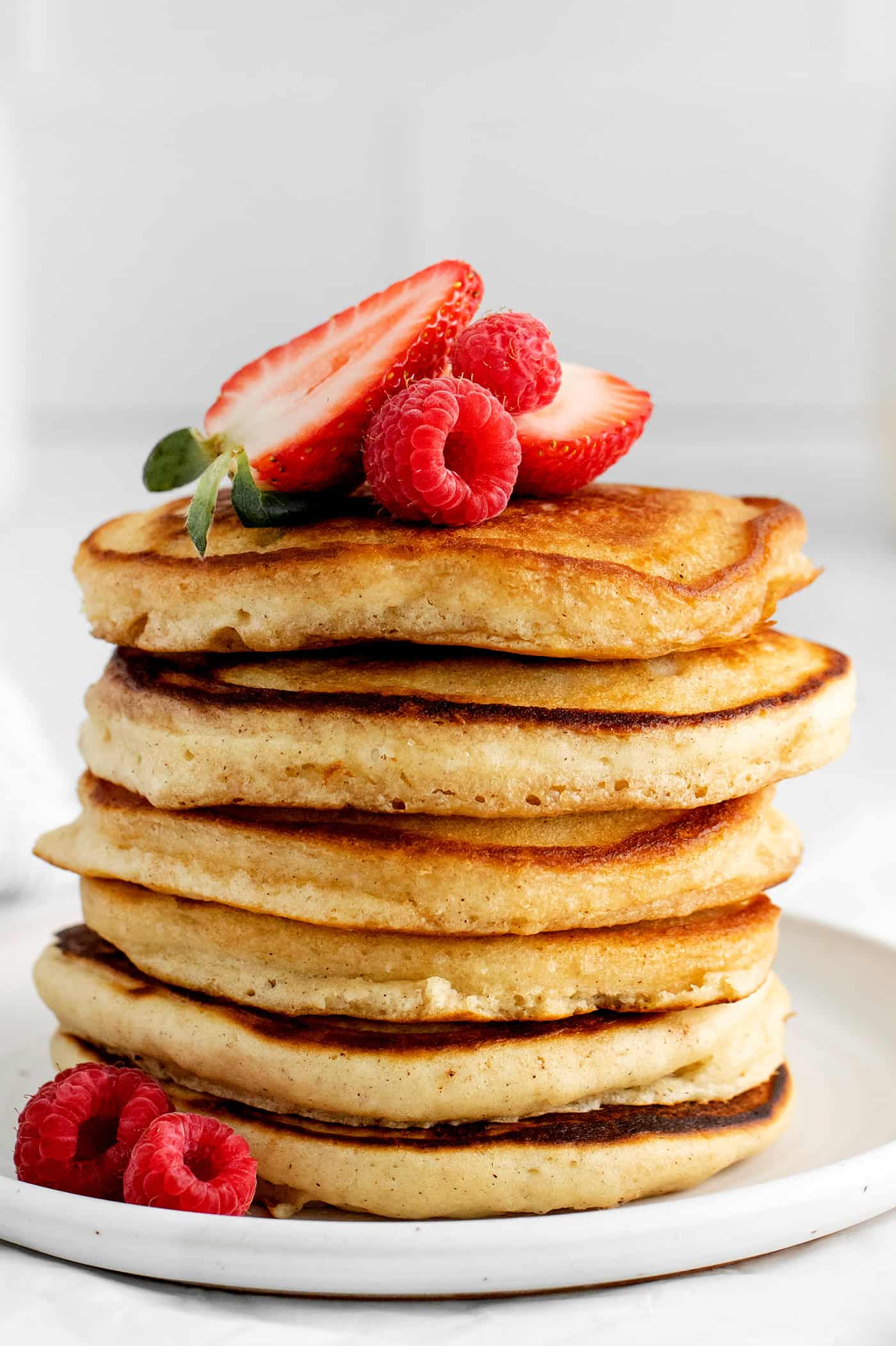 A stack of buttermilk pancakes topped with strawberries