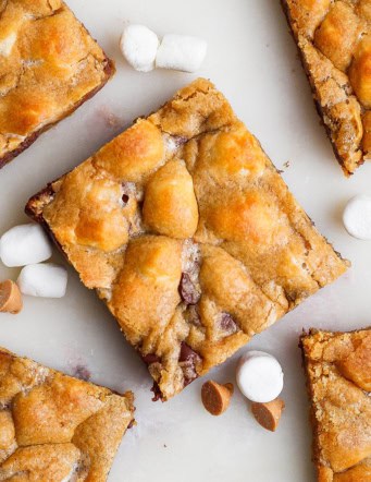Overhead view of 5 disappearing marshmallow brownies with butterscotch chips and marshmallows