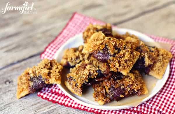 A plate of bacon bowtie snacks with a cracker base, bacon, and crumbly brown sugar topping