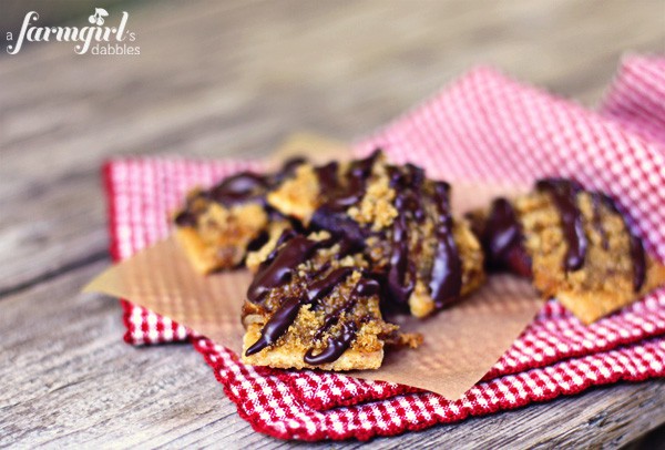 a pile of bacon bow ties drizzled with chocolate on a white plate