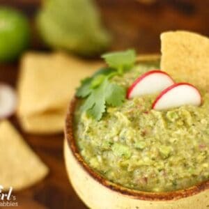 a pottery bowl of guacamole with tortilla chips