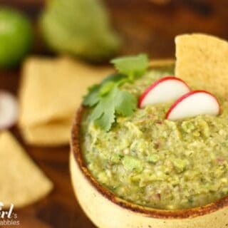a pottery bowl of guacamole with tortilla chips