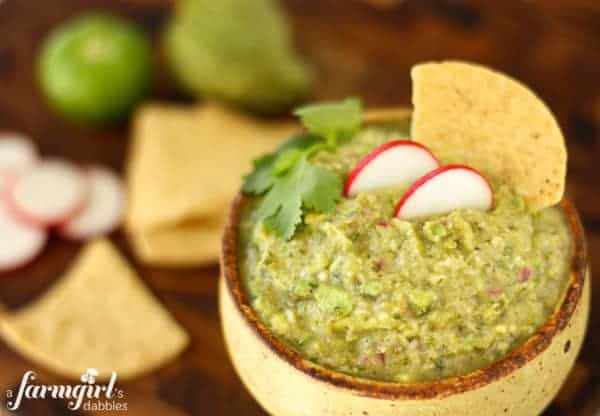 a pottery bowl of guacamole with tortilla chips