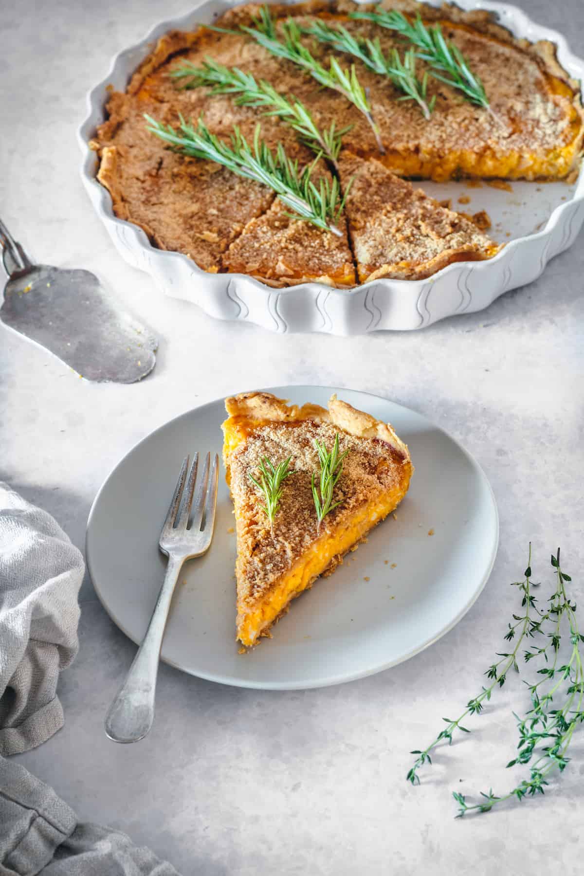 A slice of butternut squash tart with caramelized onions on a white plate