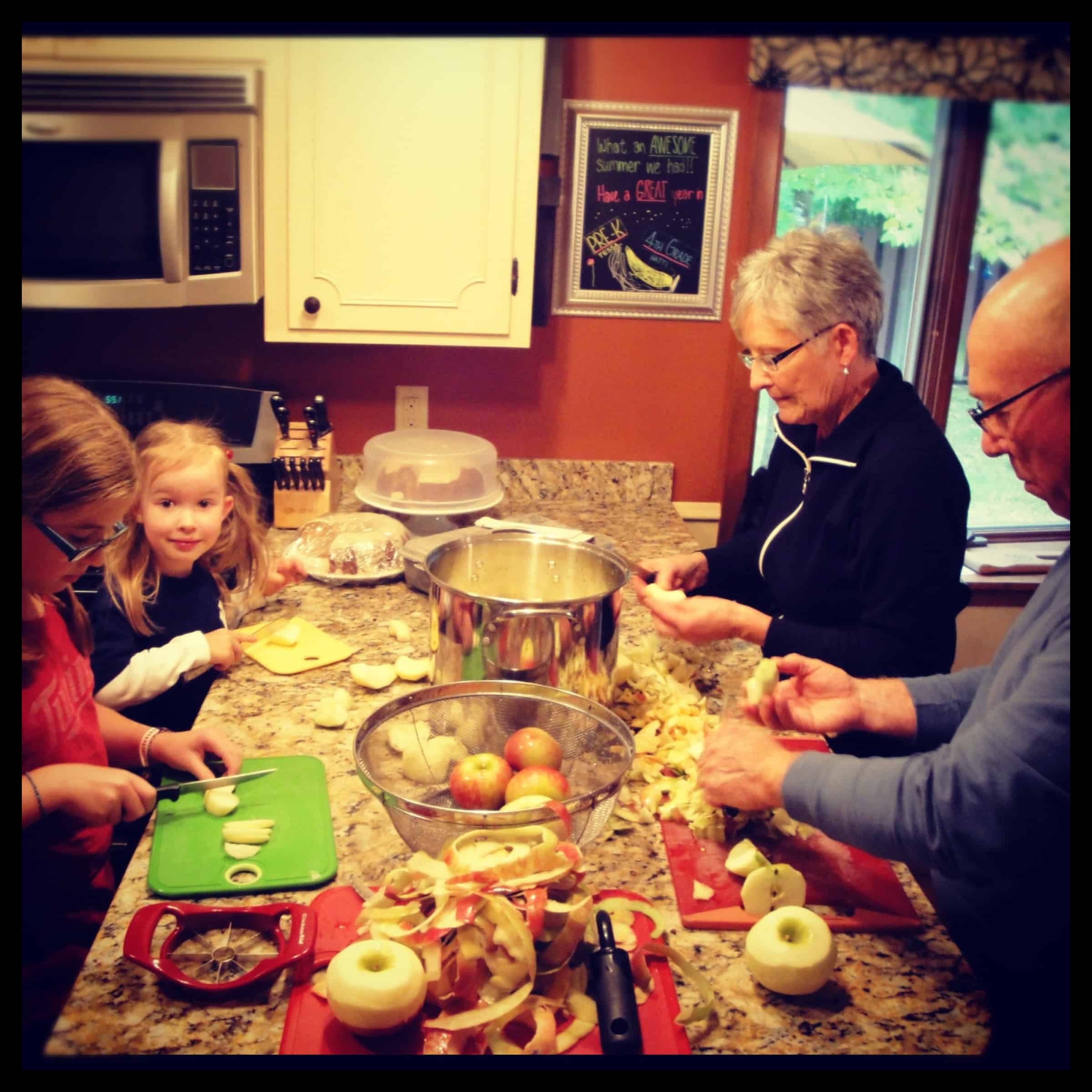 family making applesauce together in kitchen