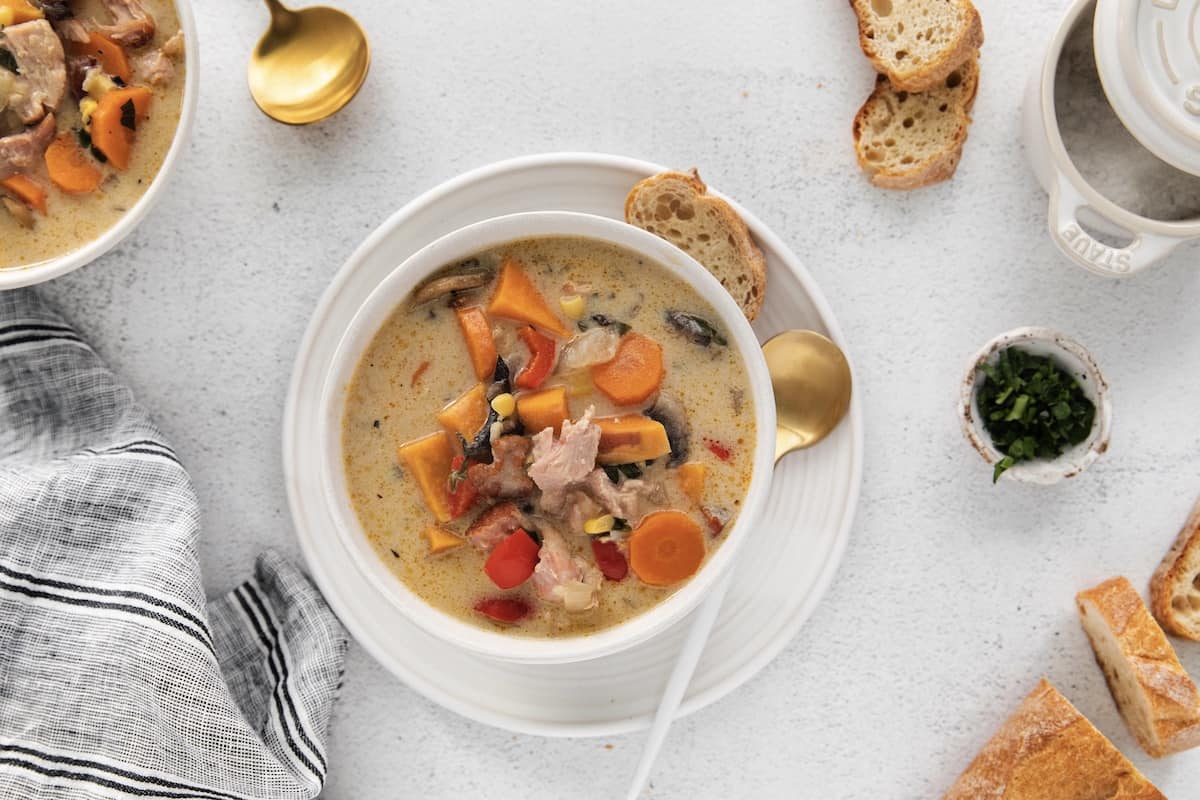 Overhead view of leftover turkey chowder in a white bowl