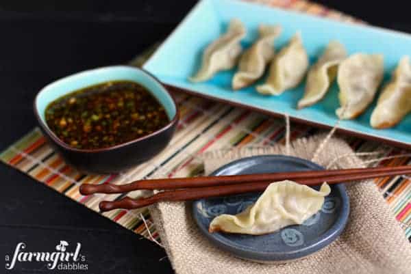 a plate of potstickers with a soy dipping sauce