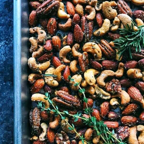 nuts on a rimmed pan with spices and herbs