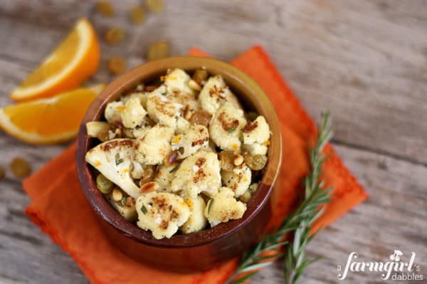 a pottery bowl of roasted cauliflower and golden raisins