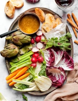 Overhead view of platter with bagna cauda, vegetables, and bread