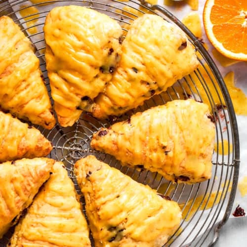 Orange scones with dark chocolate on wire cooling rack.