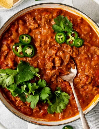 Overhead view of cheesy beef taco dip in a skillet