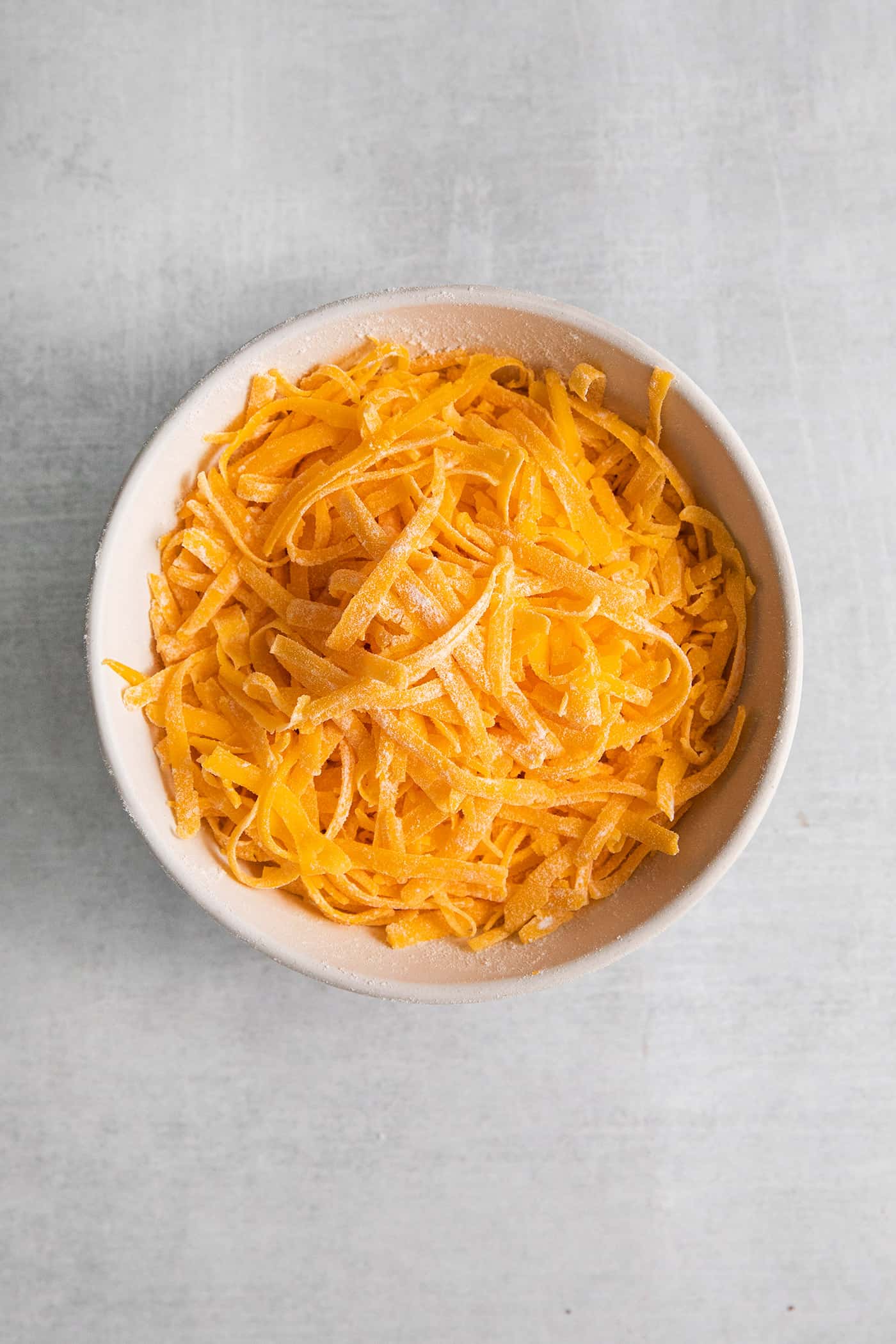 Freshly grated cheese in a white bowl