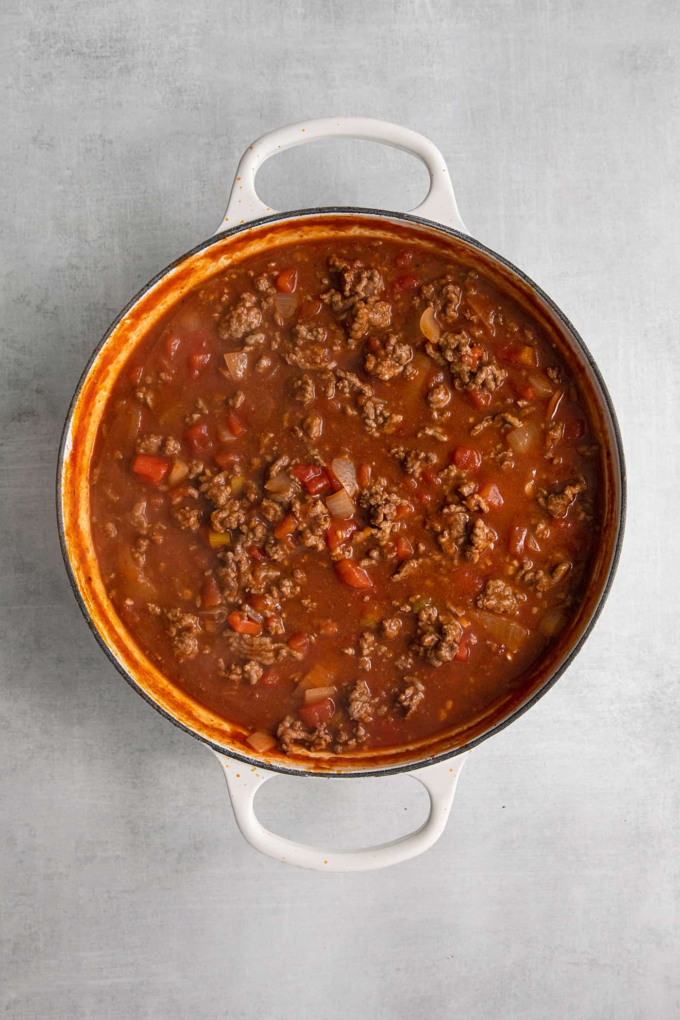 Ground beef, tomato sauce, and rotel in a skillet