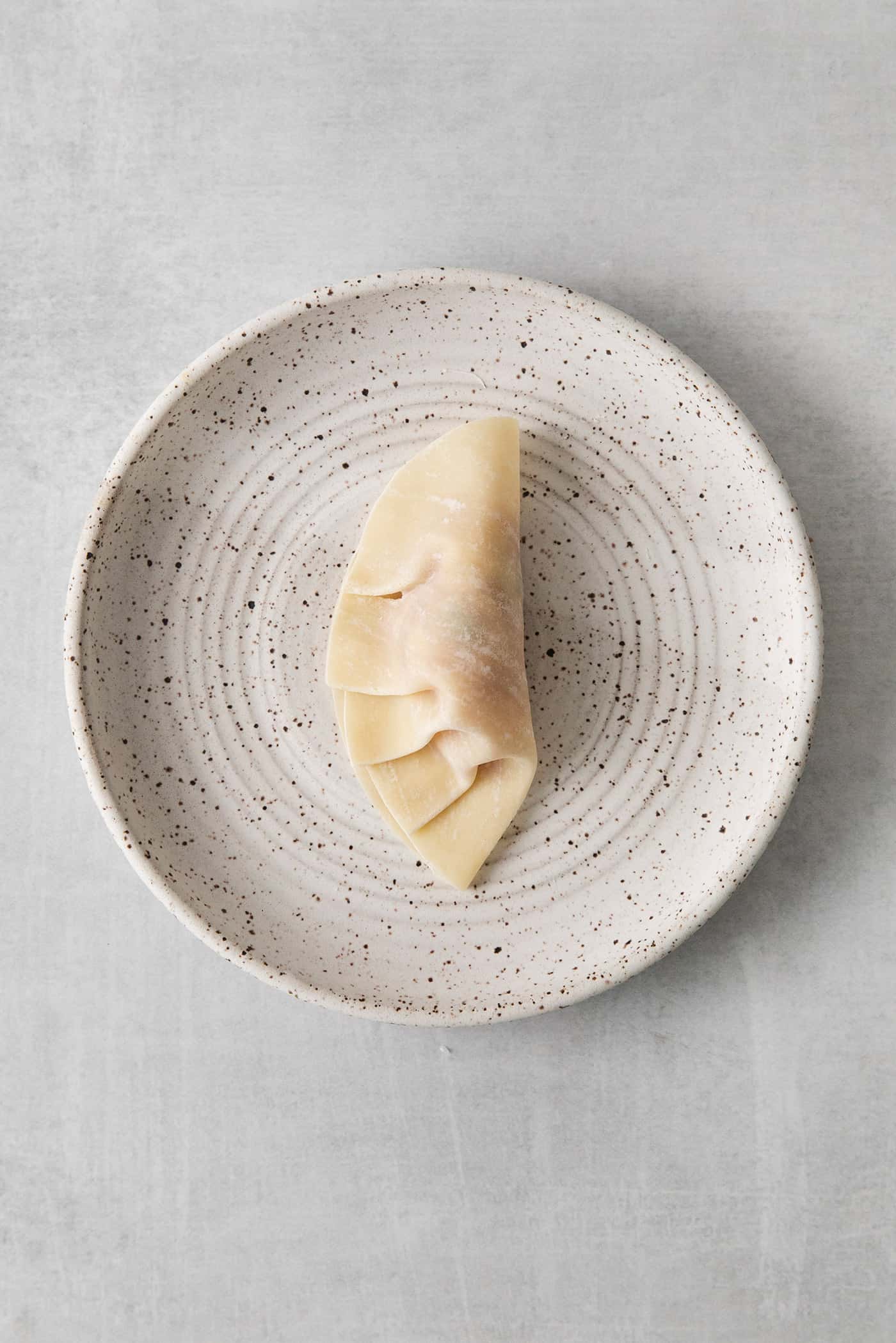 A potsticker in the process of being pleated