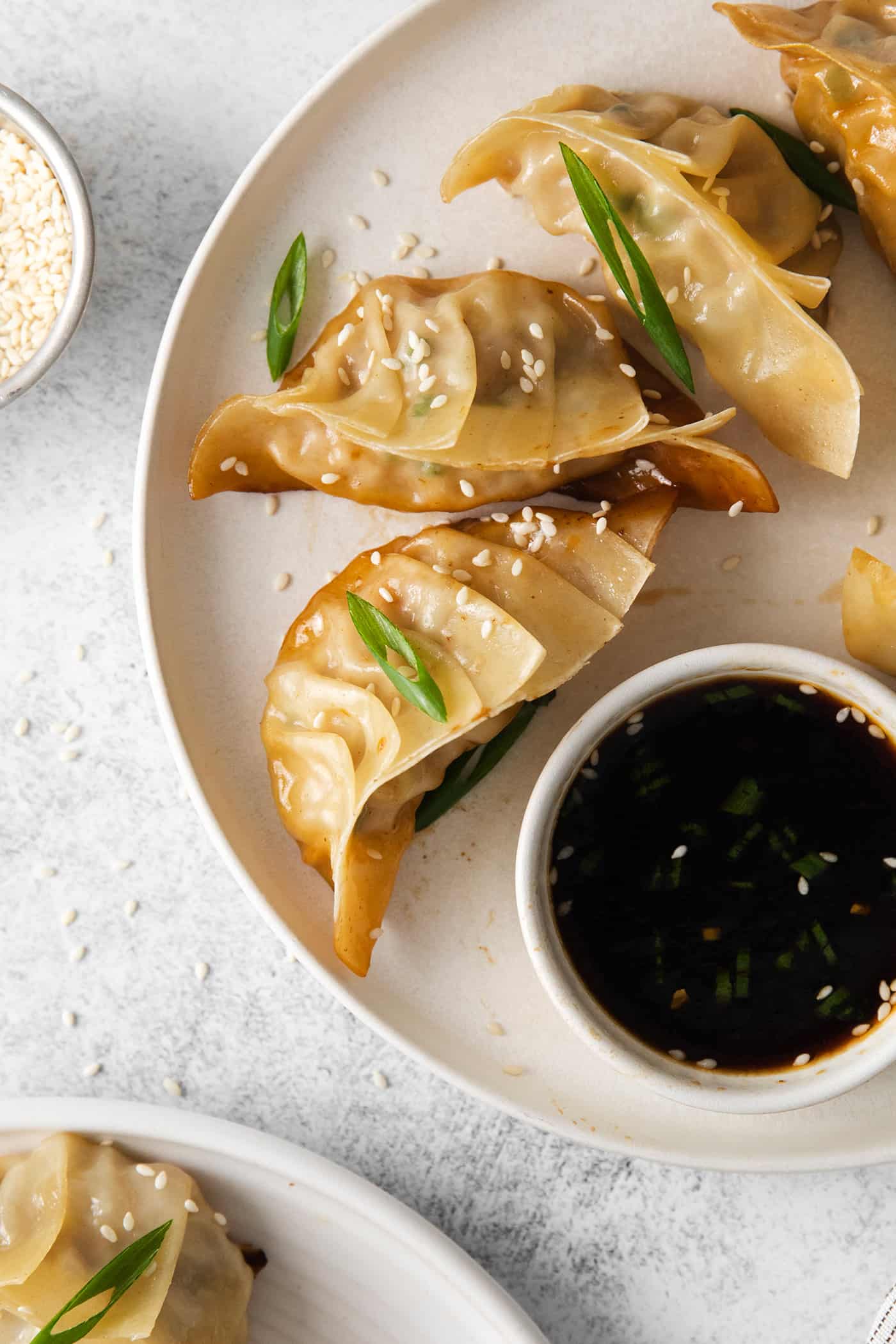 Overhead view of pork and cabbage potstickers with a dish of dipping sauce