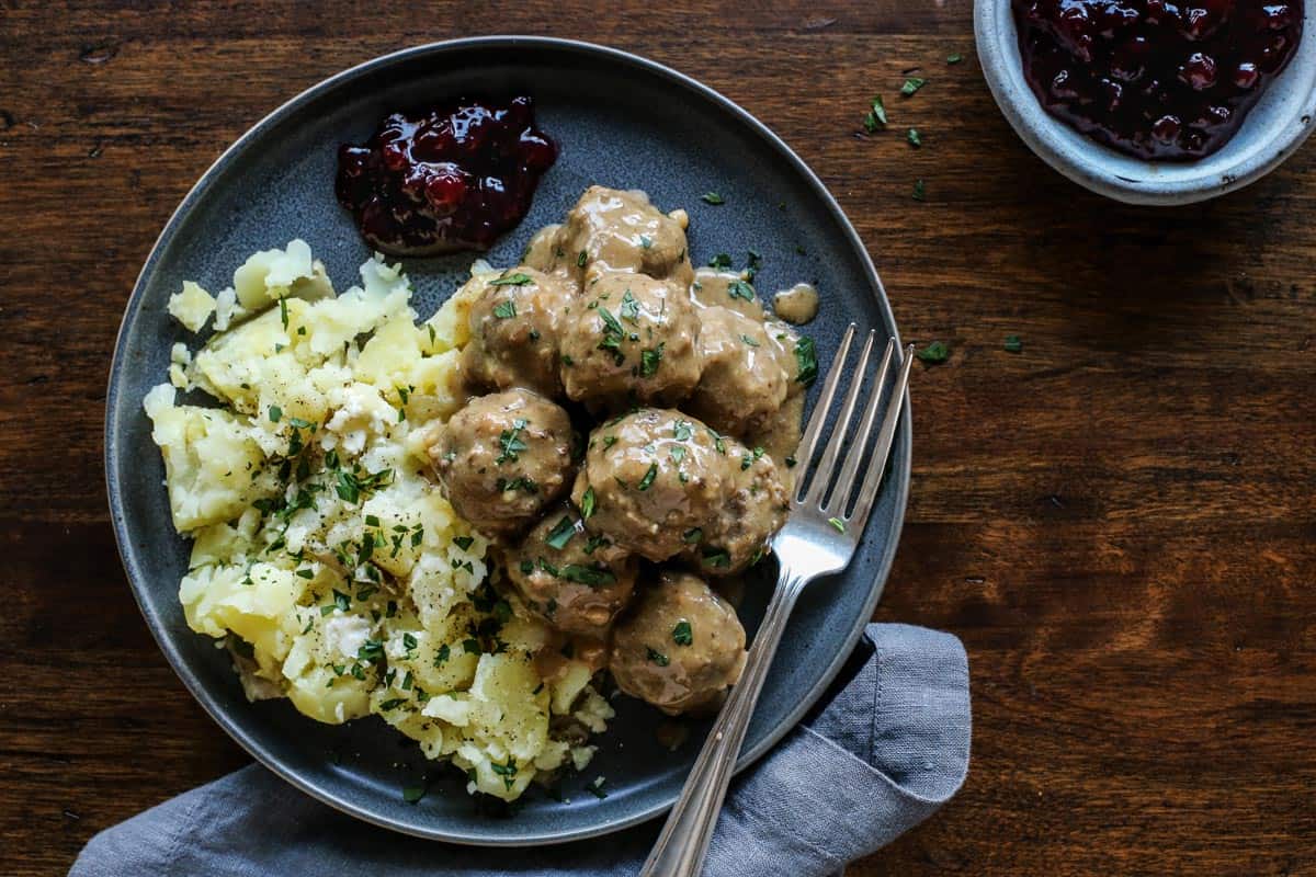 Swedish meatballs and gravy on a plate with a fork.