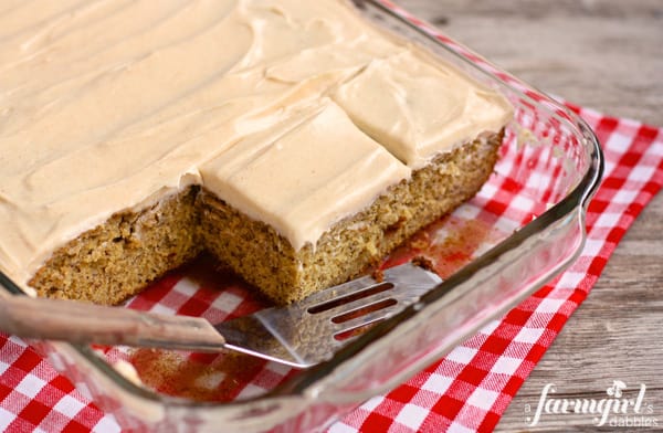 a glass baking pan of banana cake with cinnamon cream cheese frosting