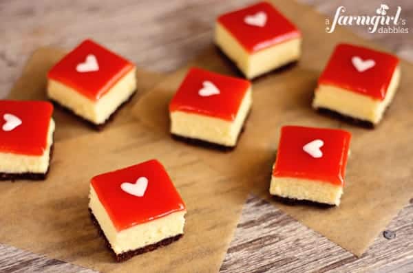 white chocolate cheesecake squares topped with strawberry glaze and a white heart