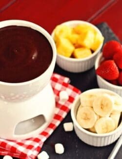 a pot of chocolate marshmallow fondue with cups of fruit