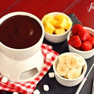 a pot of chocolate marshmallow fondue with cups of fruit