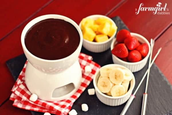 a pot of chocolate marshmallow fondue with cups of fruit