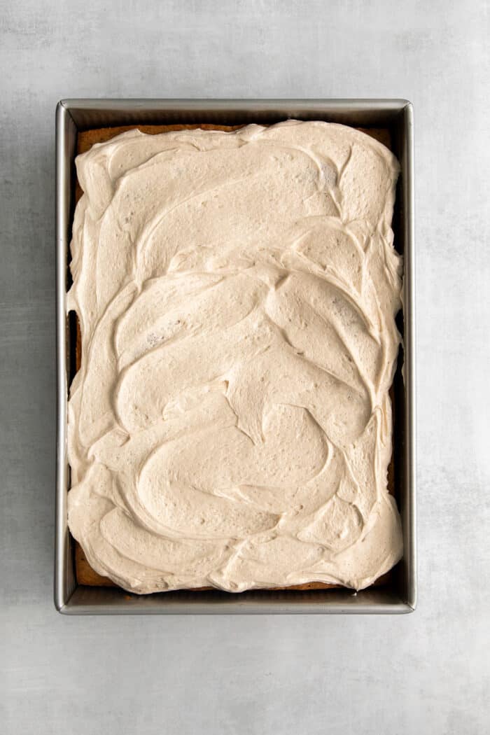 Cinnamon cream cheese frosting spread over a cake