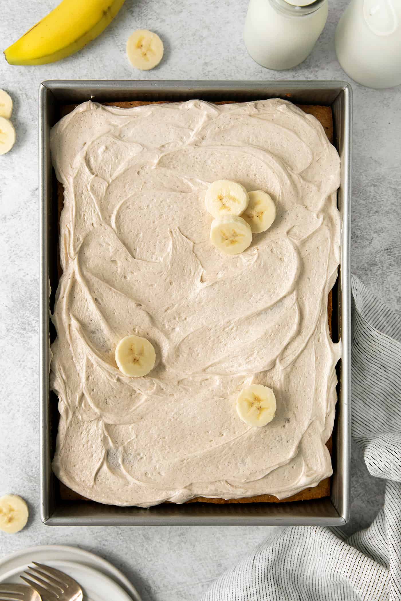 Banana cake topped with cream cheese frosting and banana slices