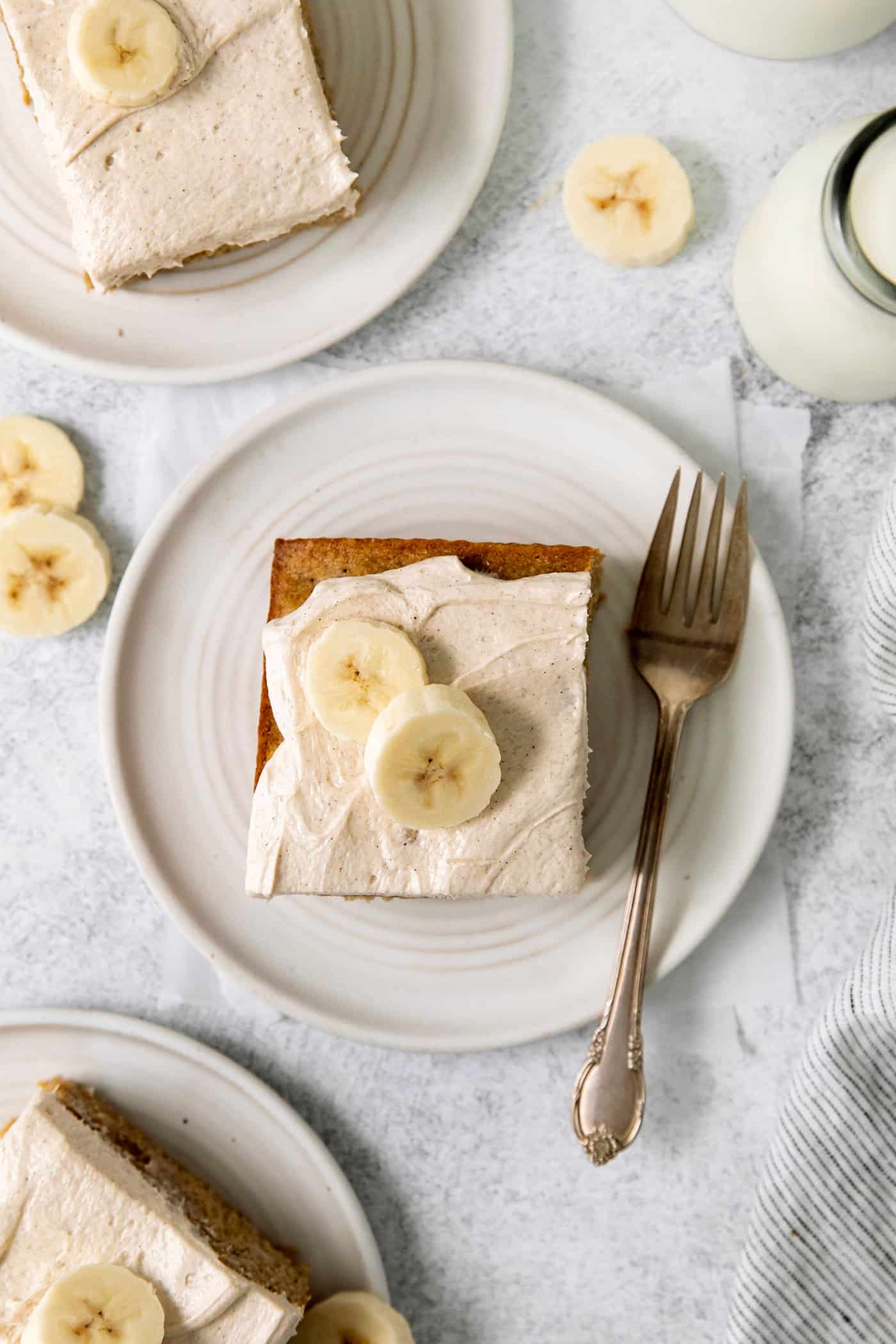 Overhead view of a slice of banana cake with cream cheese frosting