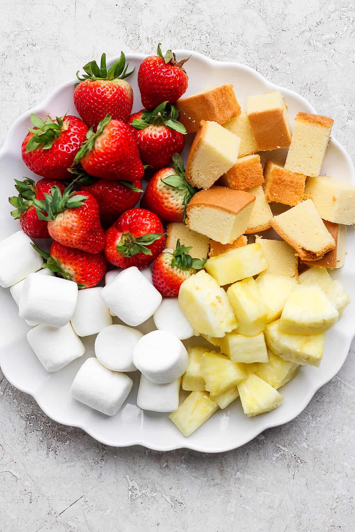 Marshmallows, strawberries, poundcake, and pineapple on plate