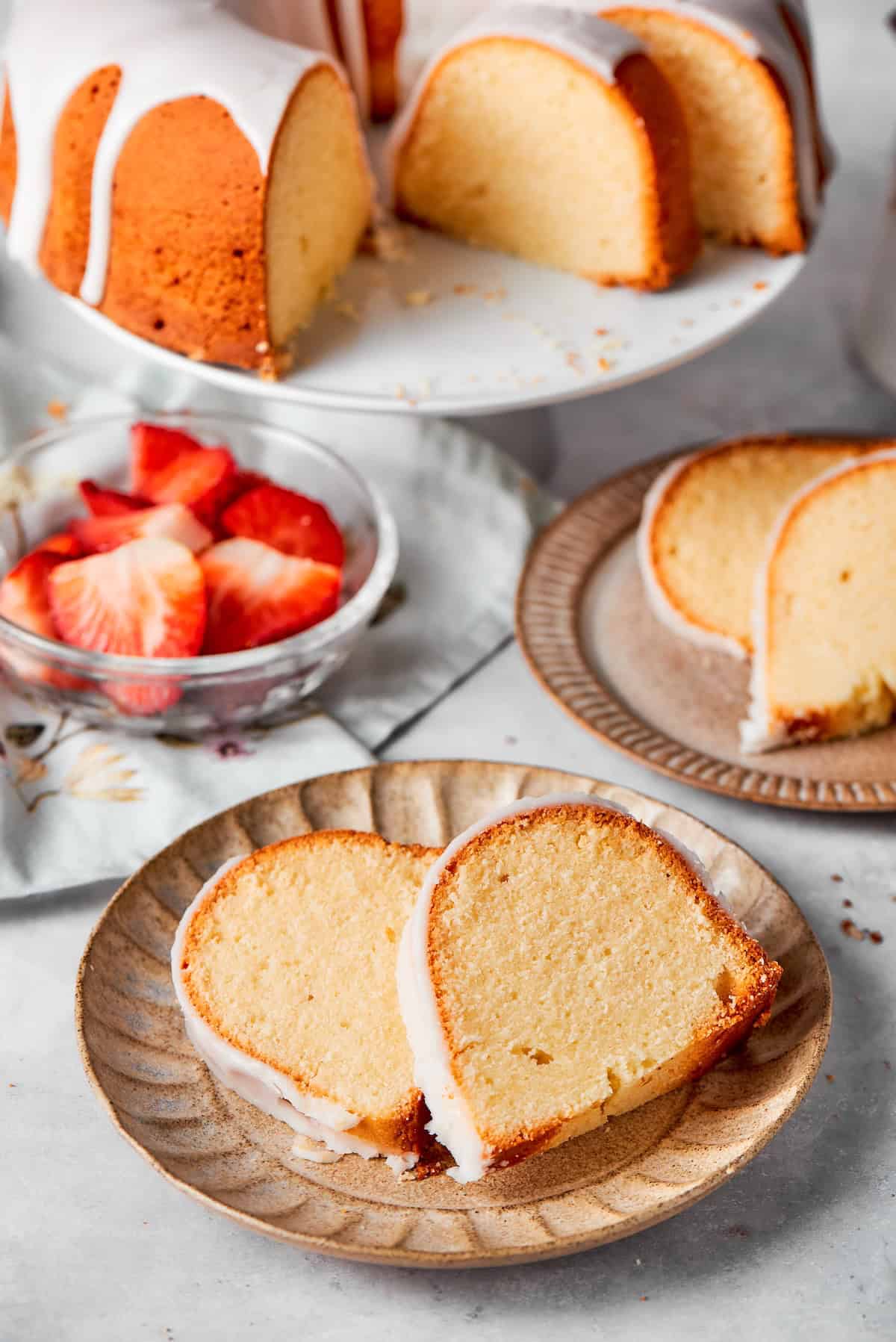 Two plates with two slices of cream cheese pound cake.