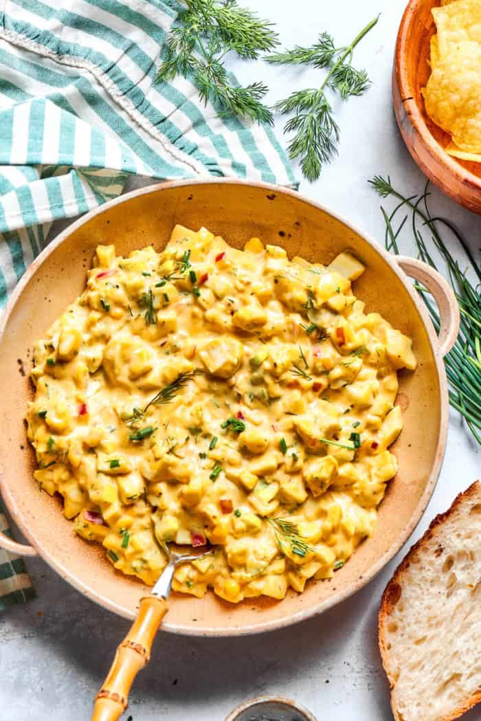 Bowl of herbed egg salad with spoon.