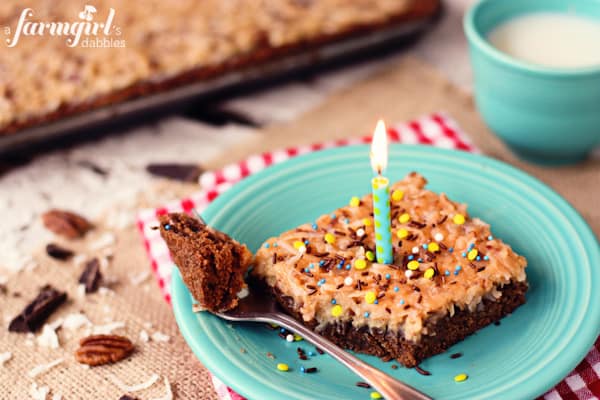 a piece of German chocolate cake with a blue candle