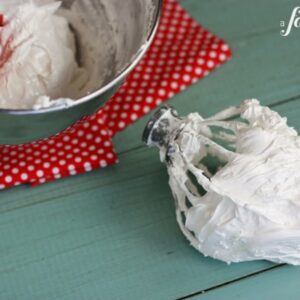a large mixing bowl and beater of homemade marshmallow cream