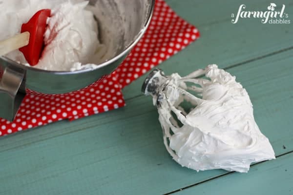 a large mixing bowl and beater of homemade marshmallow cream