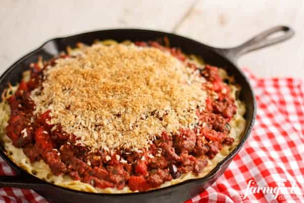 a skillet pan of Spaghetti Hotdish topped with Garlic Bread Crumbs