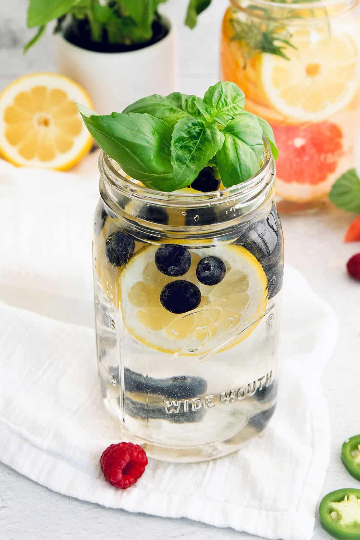 Large jar of spa water with blueberries, basil, and lemon