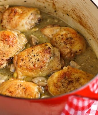 a red crockpot of Braised Chicken with Mushrooms and Green Olives