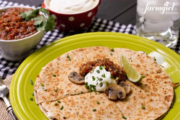 cheese, mushroom, and herb quesadilla on a green plate