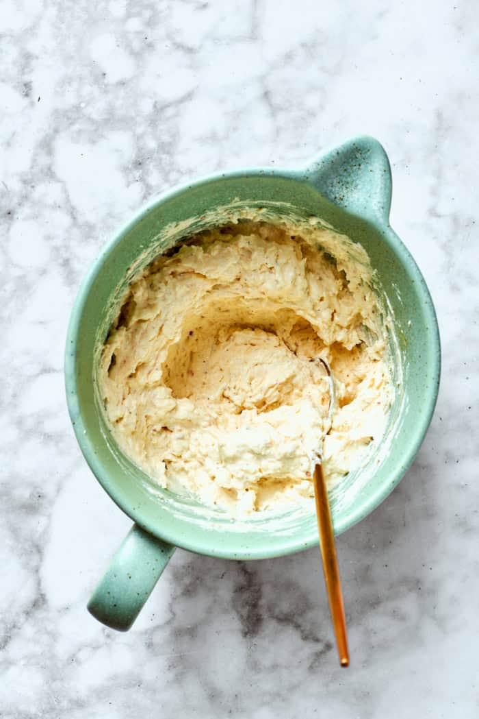 Overhead view of cheesy yum in mixing bowl with spoon