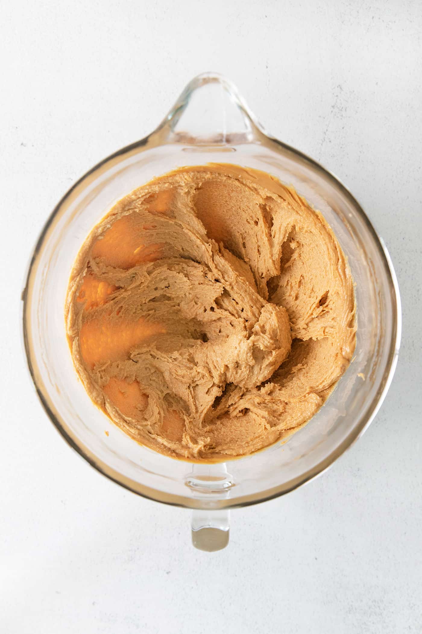 Peanut butter creamed with sugar in a mixing bowl