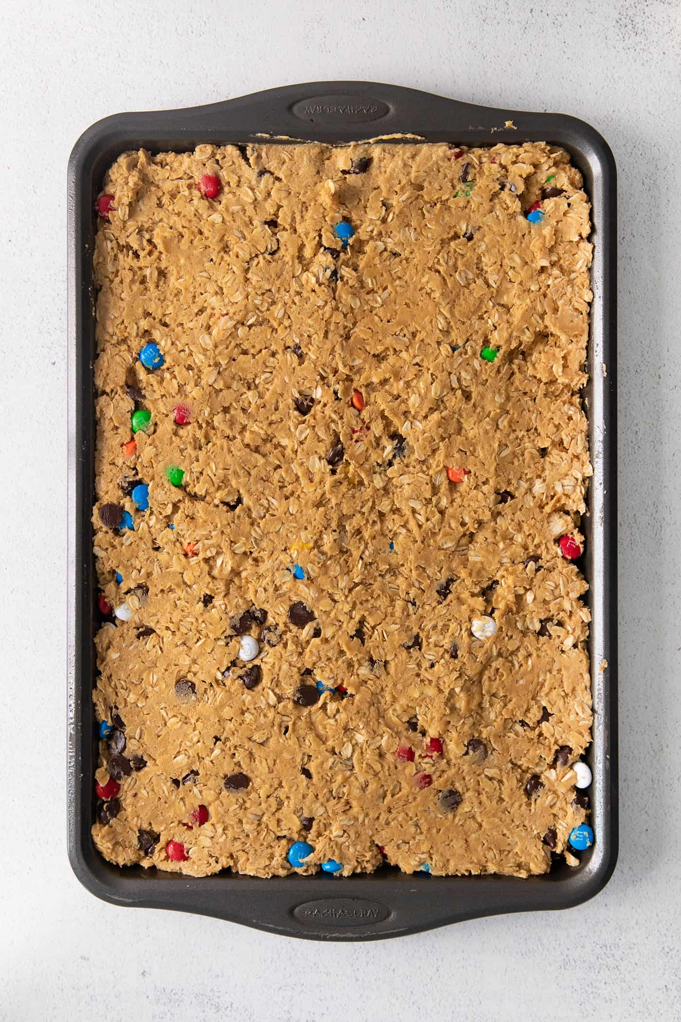 Monster cookie bar dough pressed into a baking dish