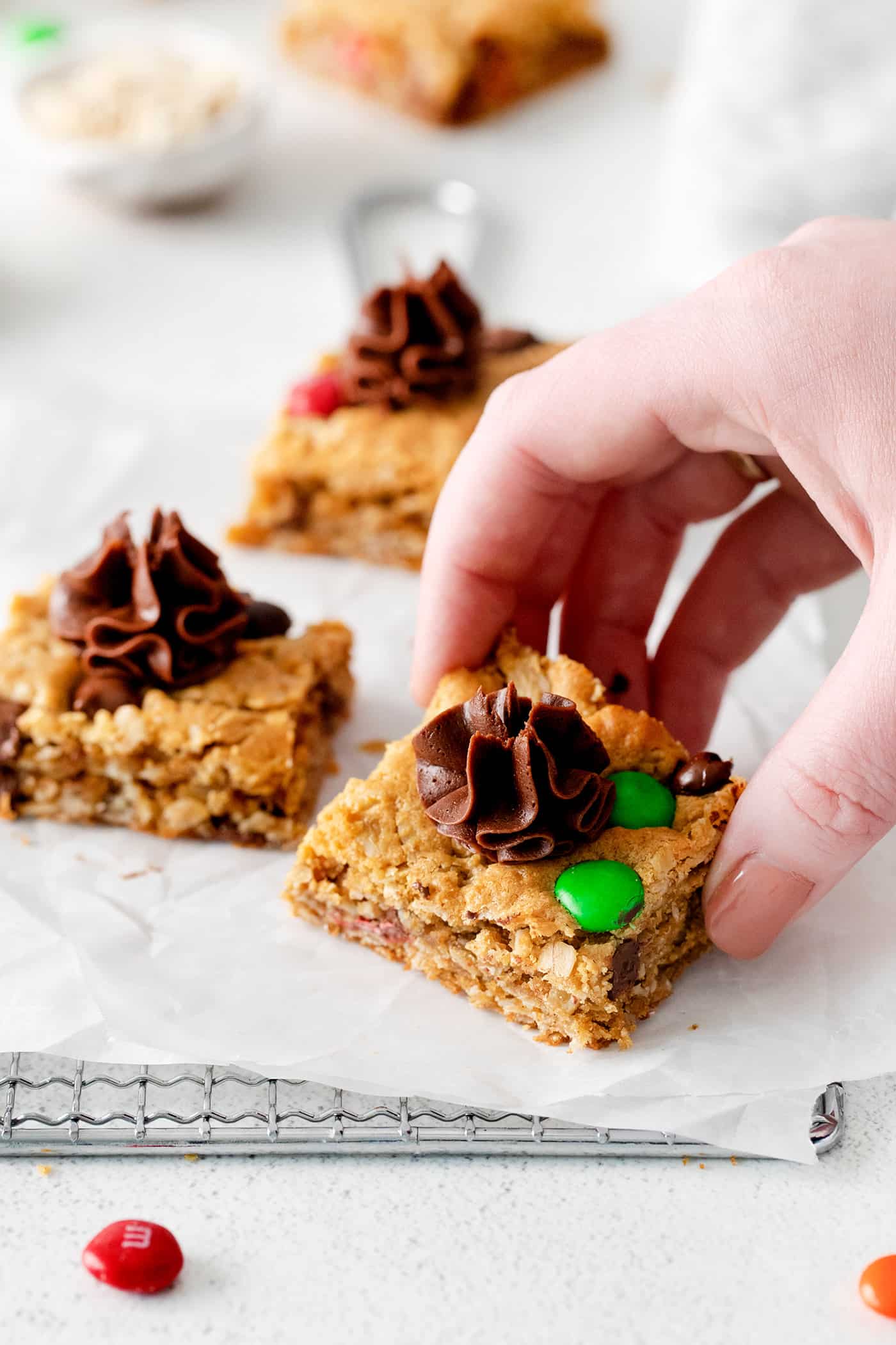 A hand grabbing a monster cookie bar