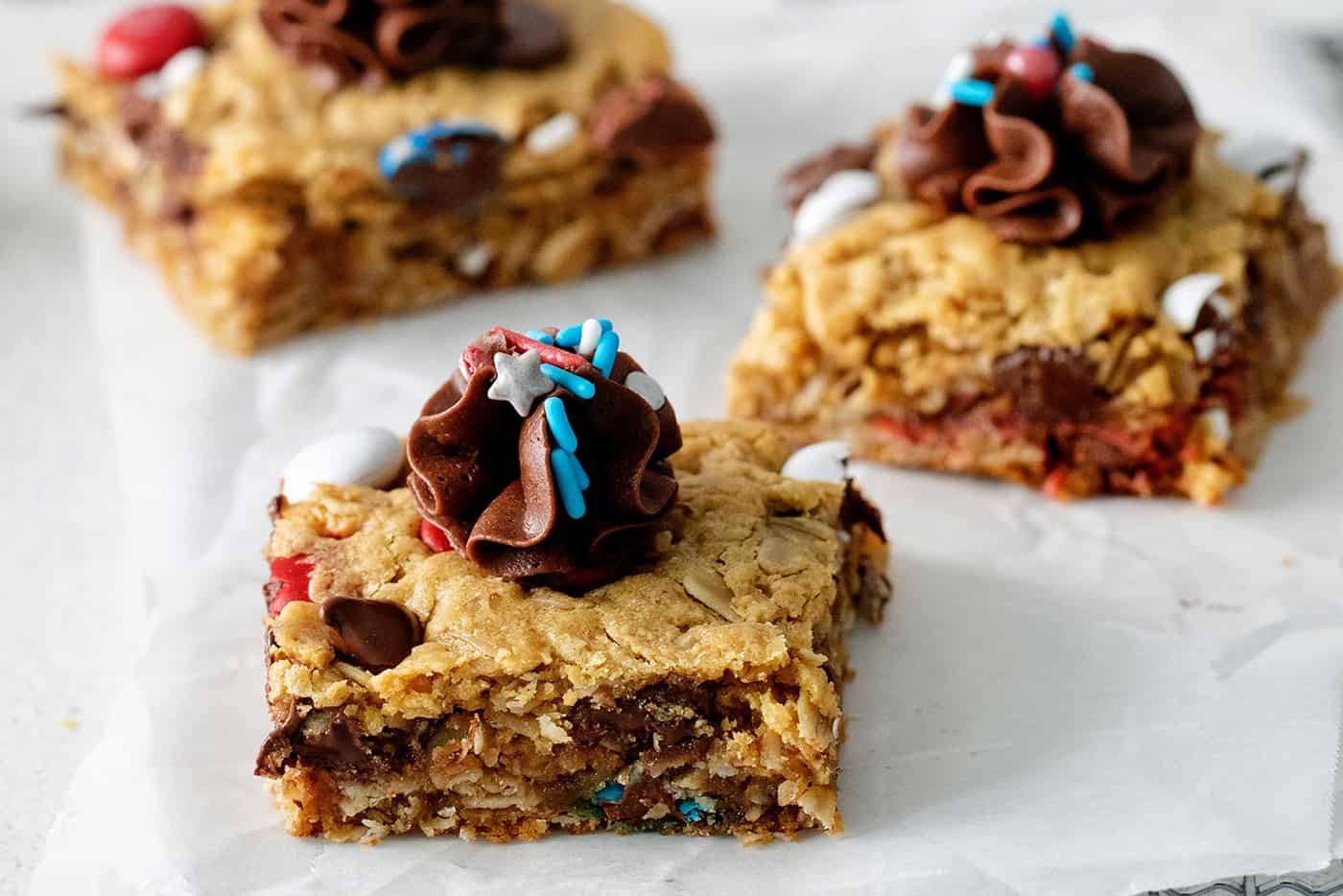 Patriotic cookie bars topped with chocolate frosting and sprinkles